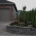 retaining wall in front of home with mulch and plants