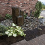 3 pillar stone water feature with hosta plant and rocks