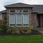 house with lawn and mulched bed with shrubs