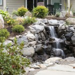waterfall feature with rocks and plants surrounding