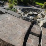 stone patio walkway next to water feature